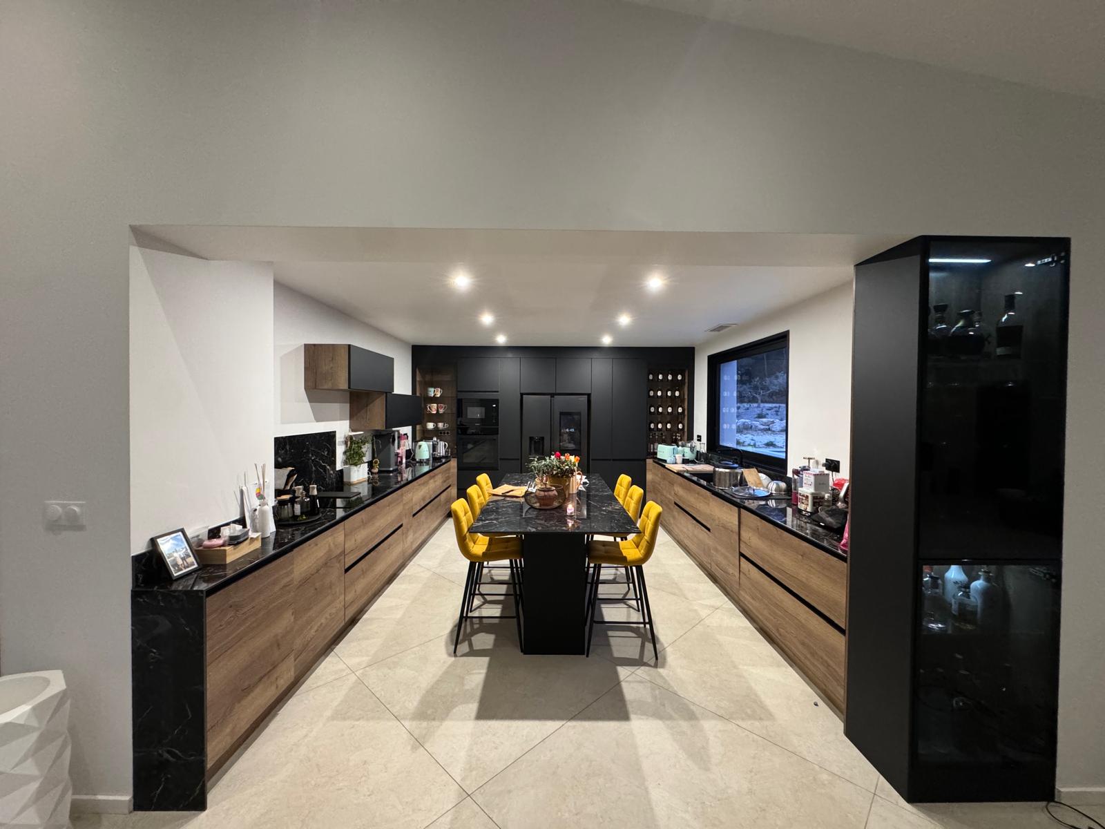 Après rénovation cuisine – cuisine équipée sur mesure noire et bois, îlot central, chaises design