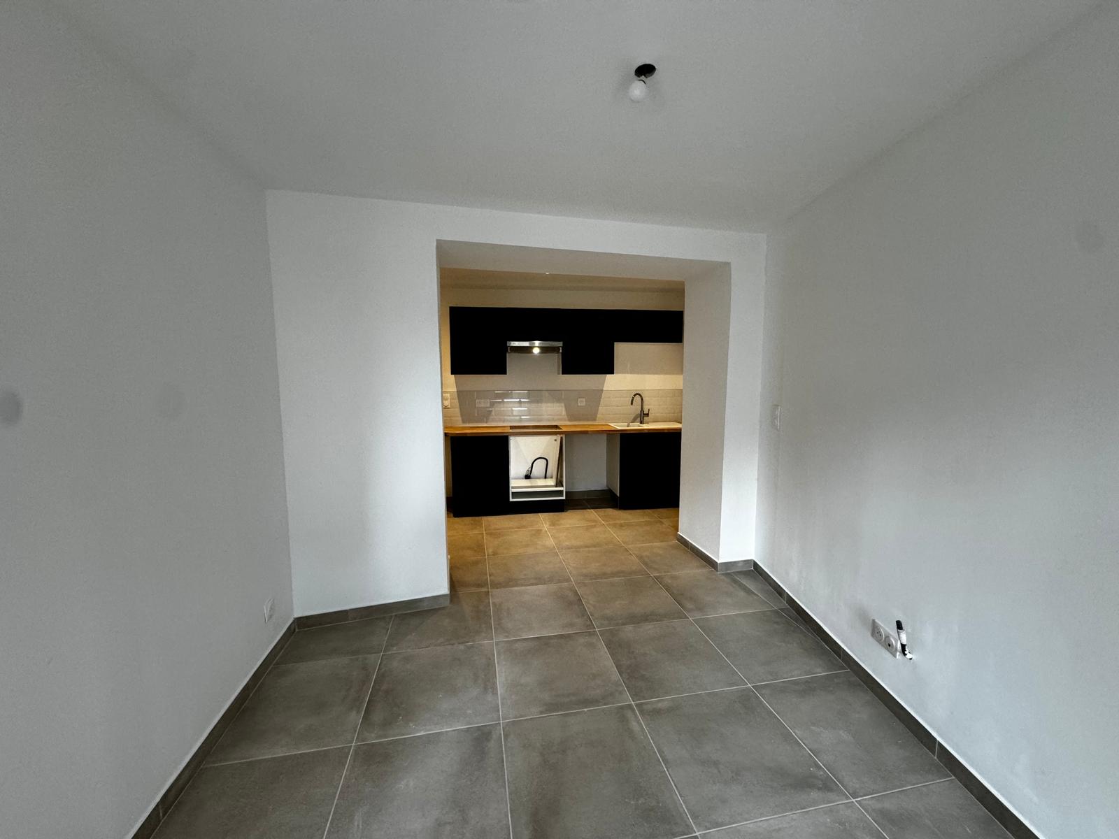 Après rénovation appartement – salon épuré, cuisine équipée noire et bois, carrelage gris