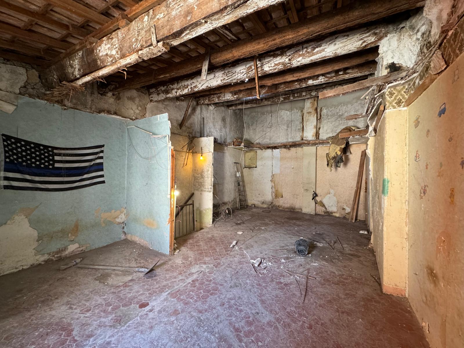 Avant rénovation intérieure – pièce vétuste, murs dégradés, plancher brut